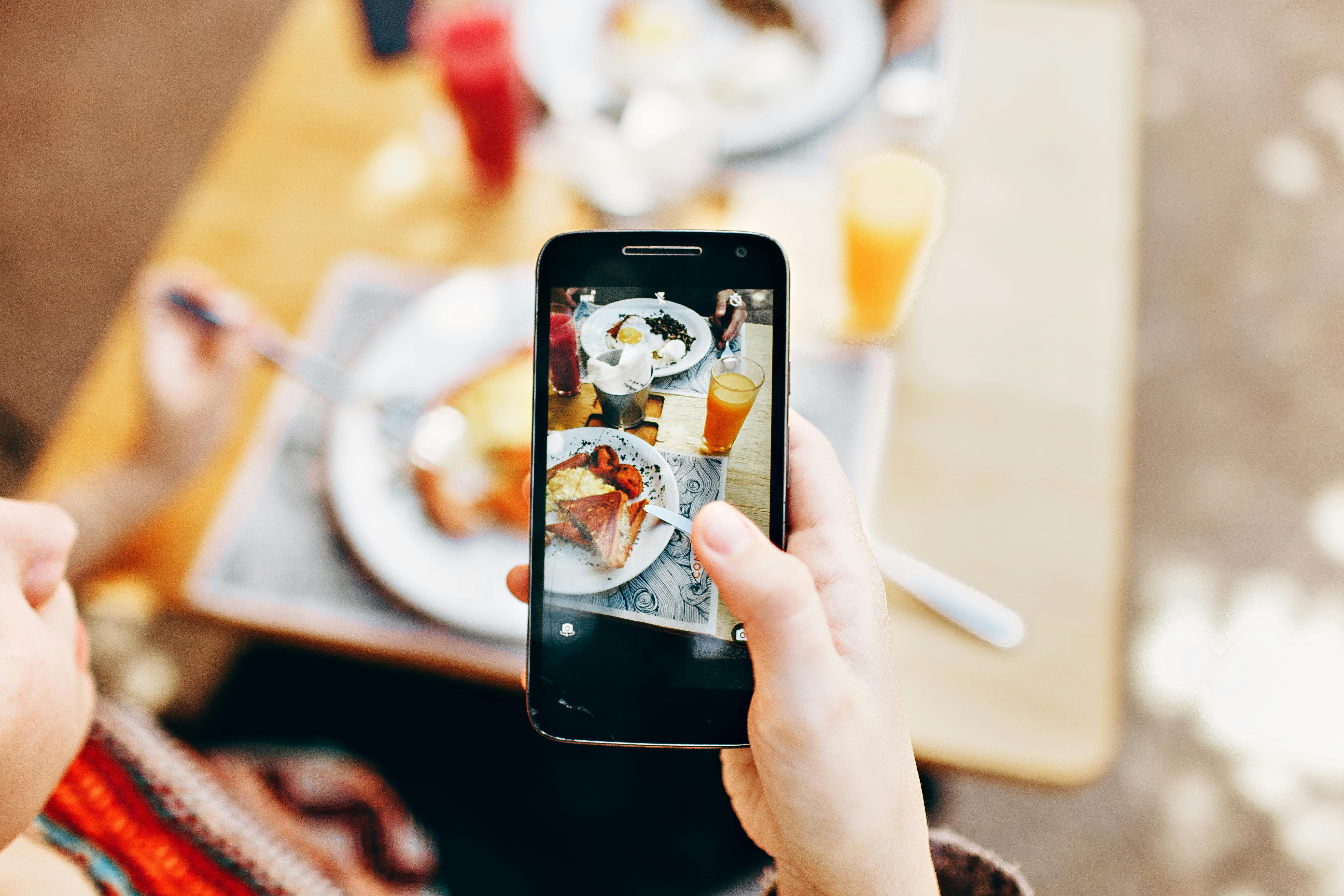Person photographing food with phone