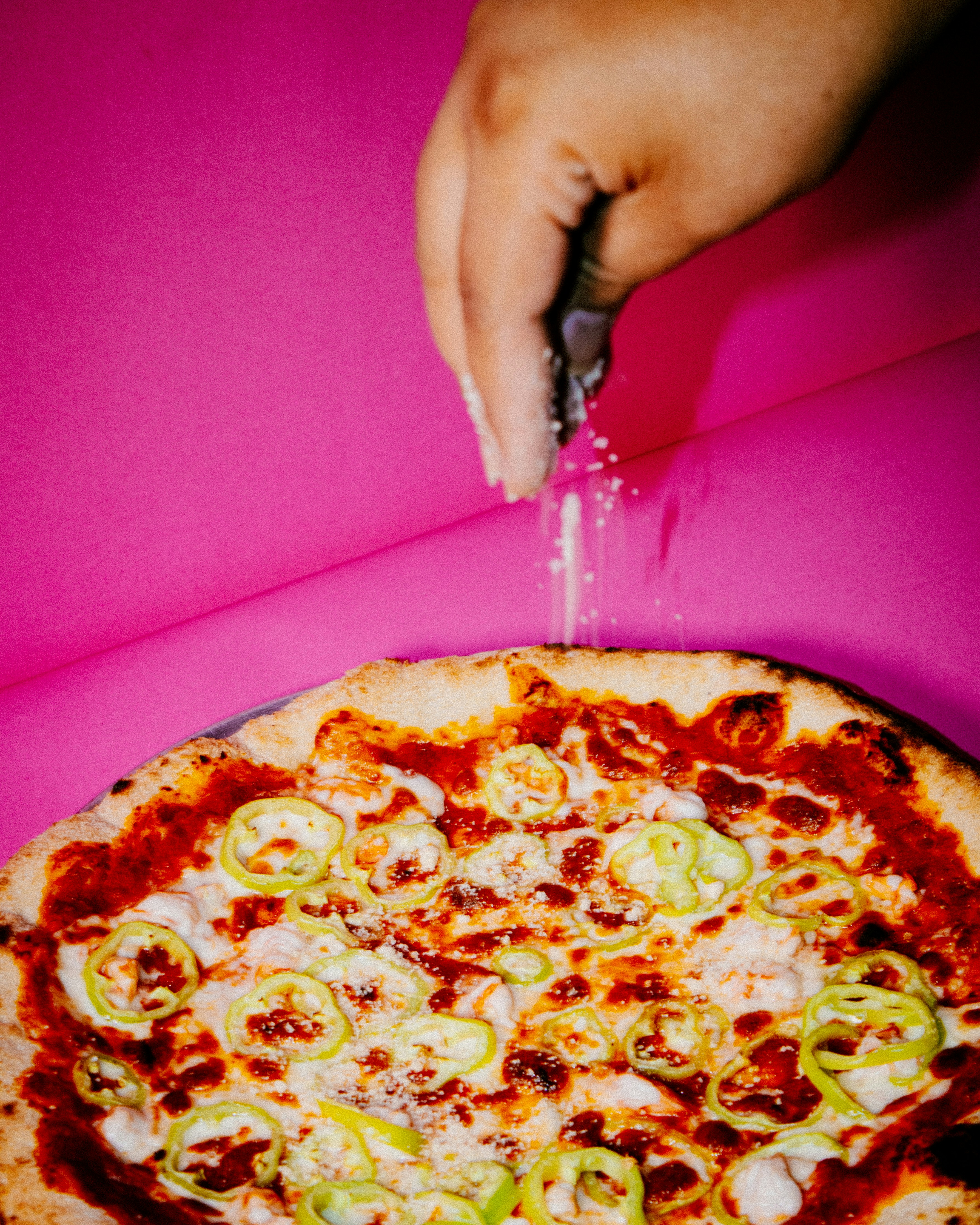 Fresh pizza on vibrant pink background
