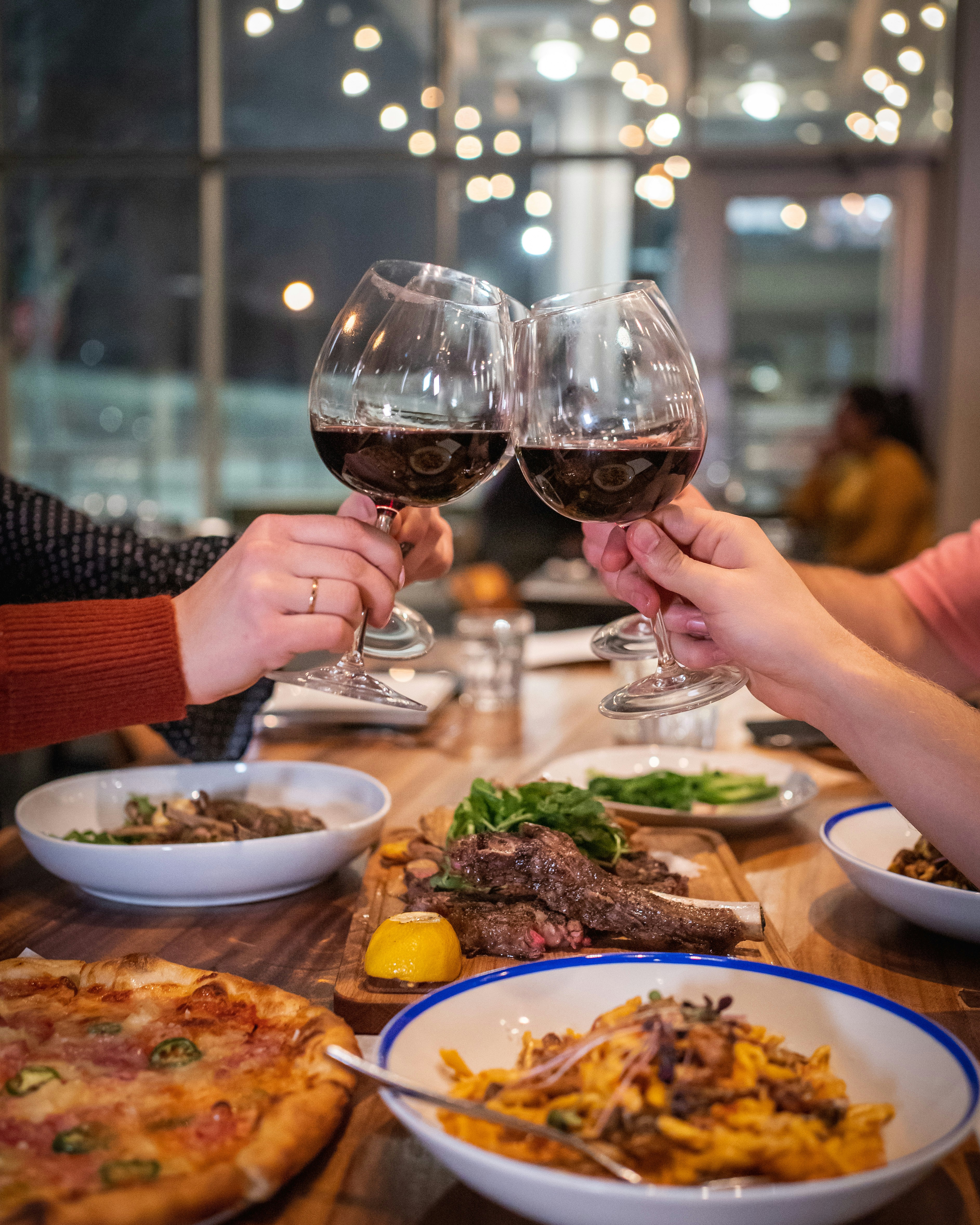 Friends toasting wine glasses over dinner